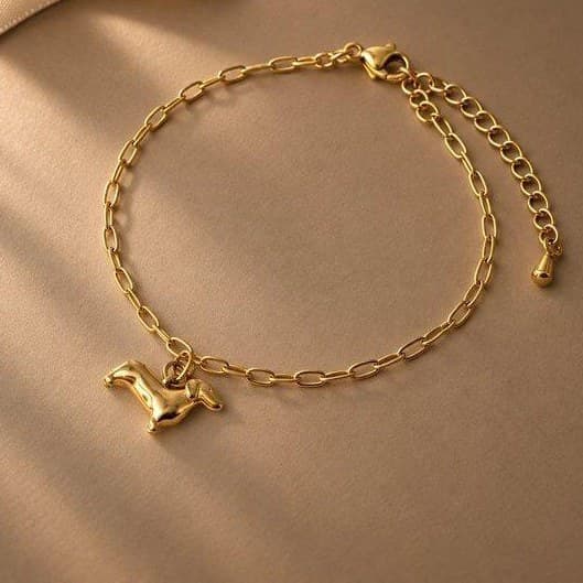 Mit ChatGPT erstellt: das goldene Dackelarmband im gleichen warmen Set mit brauner Fläche und hellem Band